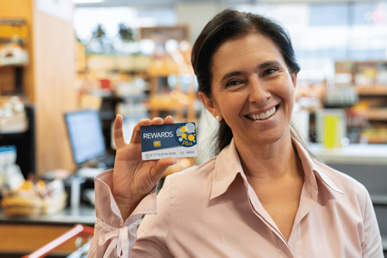 Woman holding up loyalty program card in store