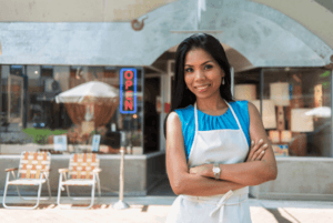 Small business owner standing outside of storefront